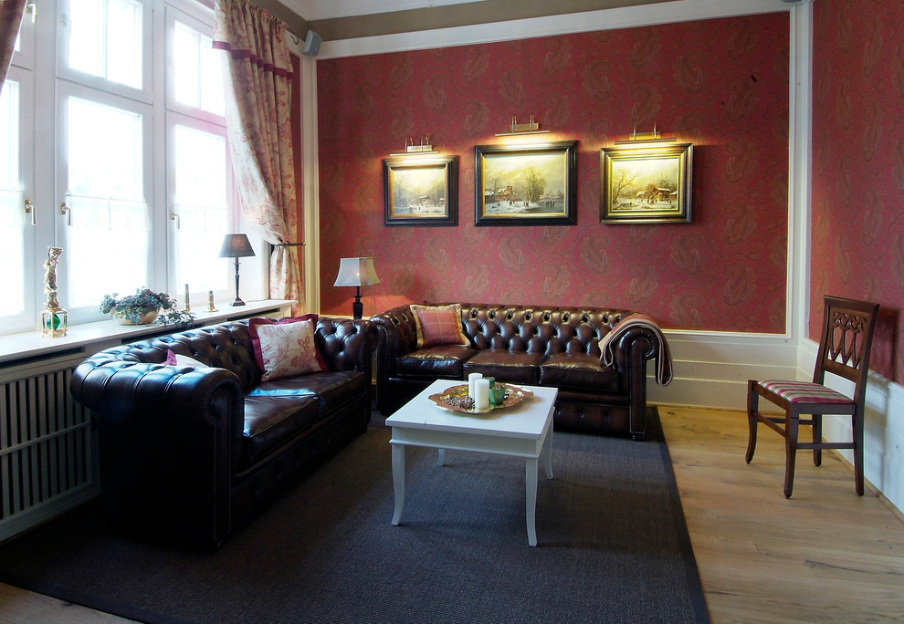 Imagen de salón para visitas cerrado clásico grande sin televisor con paredes rojas, suelo de madera clara, estufa de leña y marco de chimenea de madera