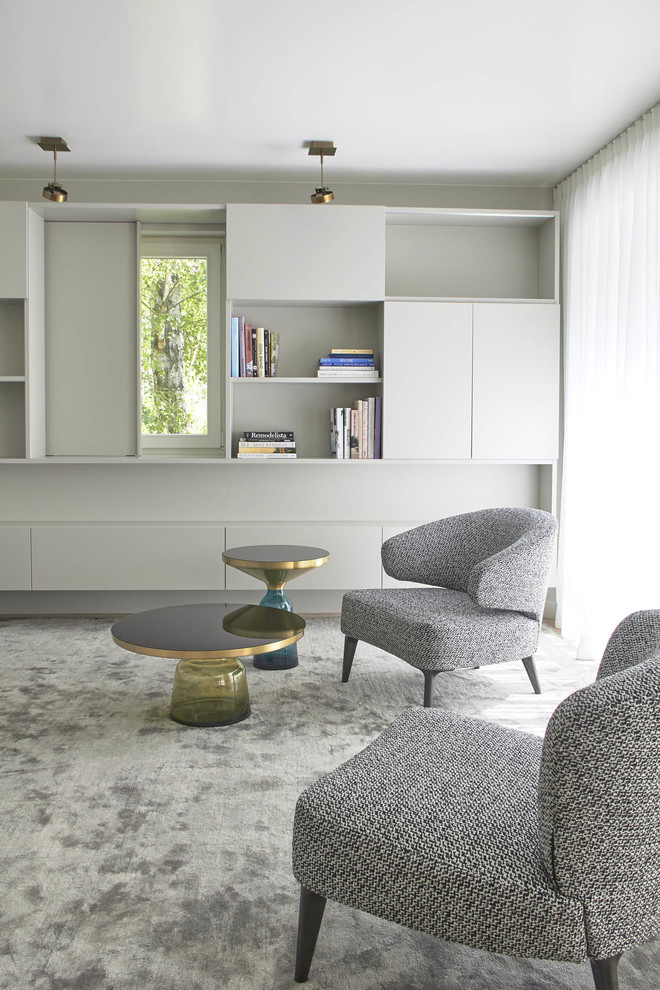 Foto de biblioteca en casa abierta tradicional de tamaño medio con paredes grises, suelo de madera pintada, televisor retractable y suelo gris