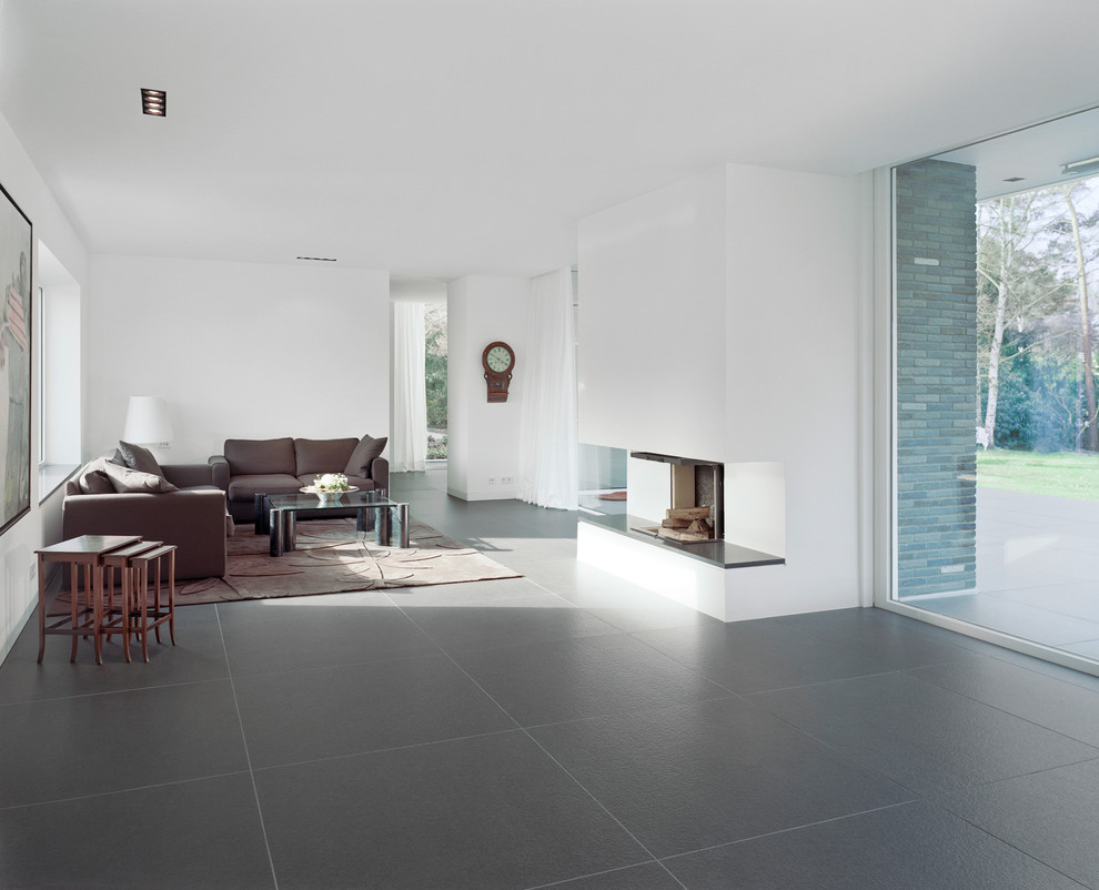 Foto di un soggiorno minimal aperto e di medie dimensioni con pareti bianche, camino classico, nessuna TV e pavimento grigio