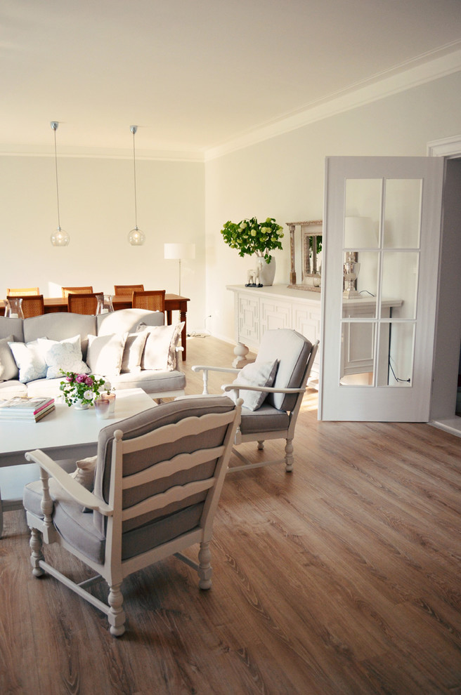 Imagen de sala de estar abierta tradicional grande con paredes grises y suelo de madera en tonos medios