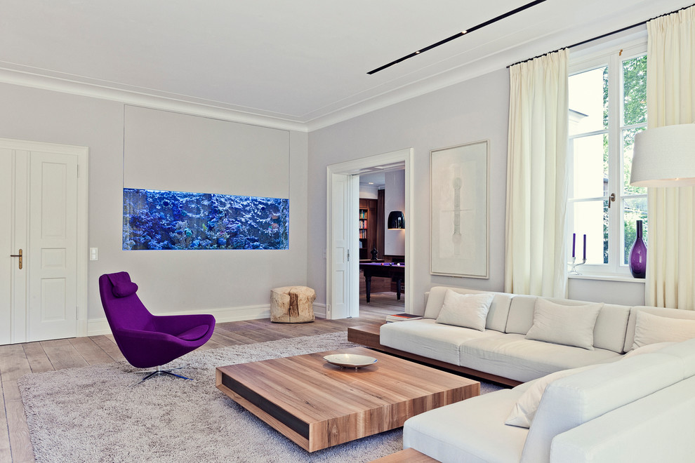 Mittelgroßes, Abgetrenntes Modernes Wohnzimmer mit grauer Wandfarbe, braunem Holzboden und braunem Boden in Köln