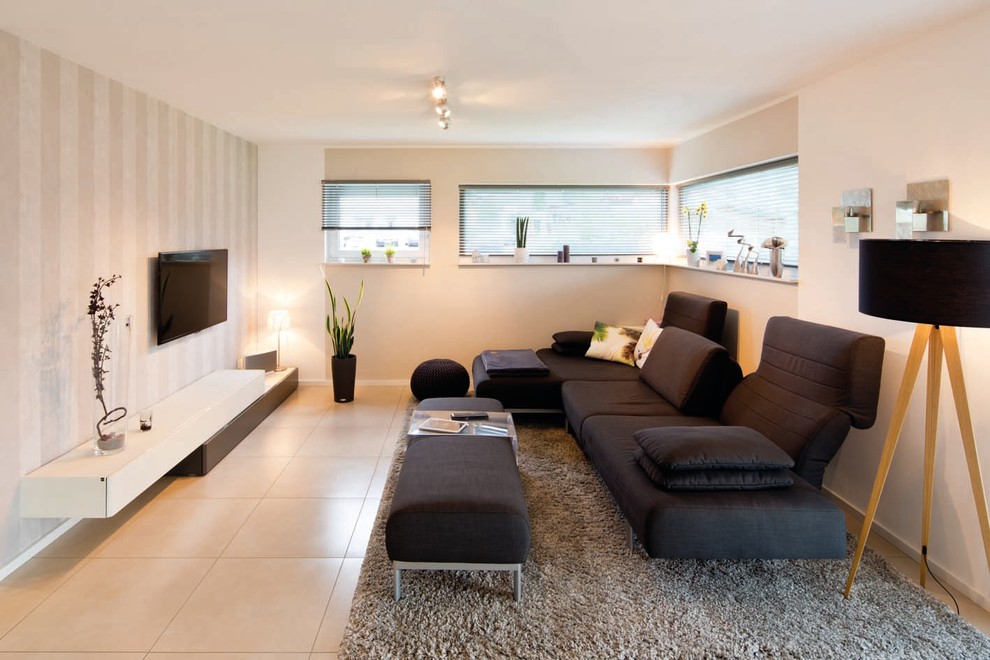 Offenes Modernes Wohnzimmer ohne Kamin mit beiger Wandfarbe, Terrakottaboden, TV-Wand und beigem Boden in Sonstige
