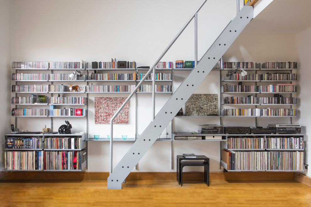 Mittelgroßes, Fernseherloses, Offenes Modernes Wohnzimmer ohne Kamin mit weißer Wandfarbe und braunem Holzboden in München