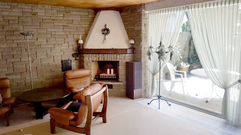 Стильный дизайн: гостиная комната среднего размера в современном стиле с угловым камином, фасадом камина из камня, черным полом и панелями на стенах - последний тренд