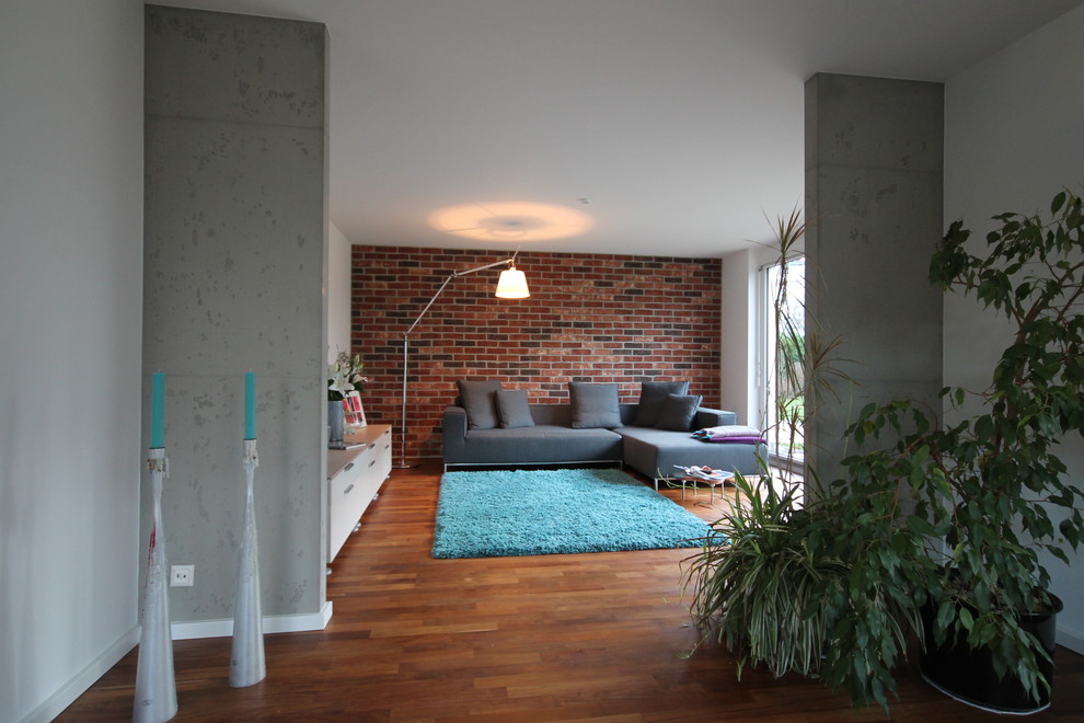 Offenes Modernes Wohnzimmer mit weißer Wandfarbe und braunem Holzboden in Stuttgart