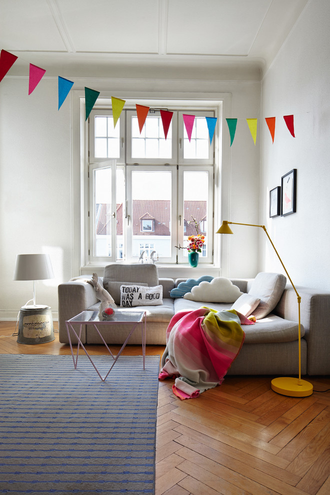 Kleines Modernes Wohnzimmer mit weißer Wandfarbe und braunem Holzboden in München