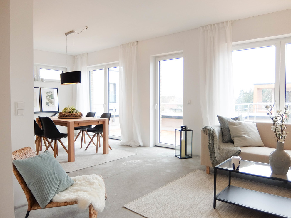 Skandinavisches Wohnzimmer mit weißer Wandfarbe, Betonboden und grauem Boden in Bremen