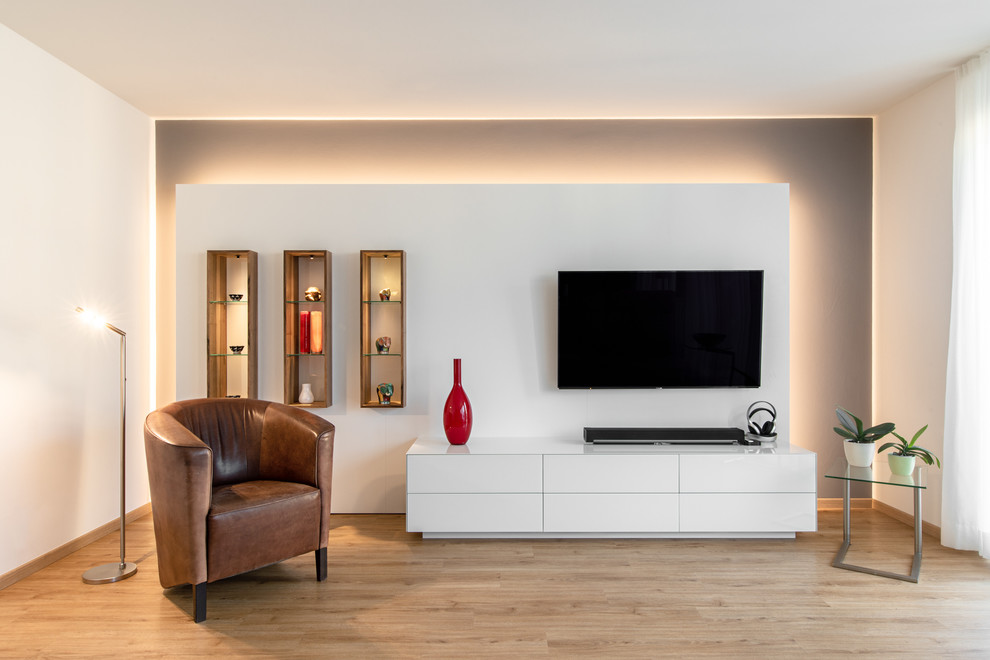 Ejemplo de salón abierto contemporáneo de tamaño medio con paredes grises, suelo vinílico, televisor colgado en la pared y suelo marrón