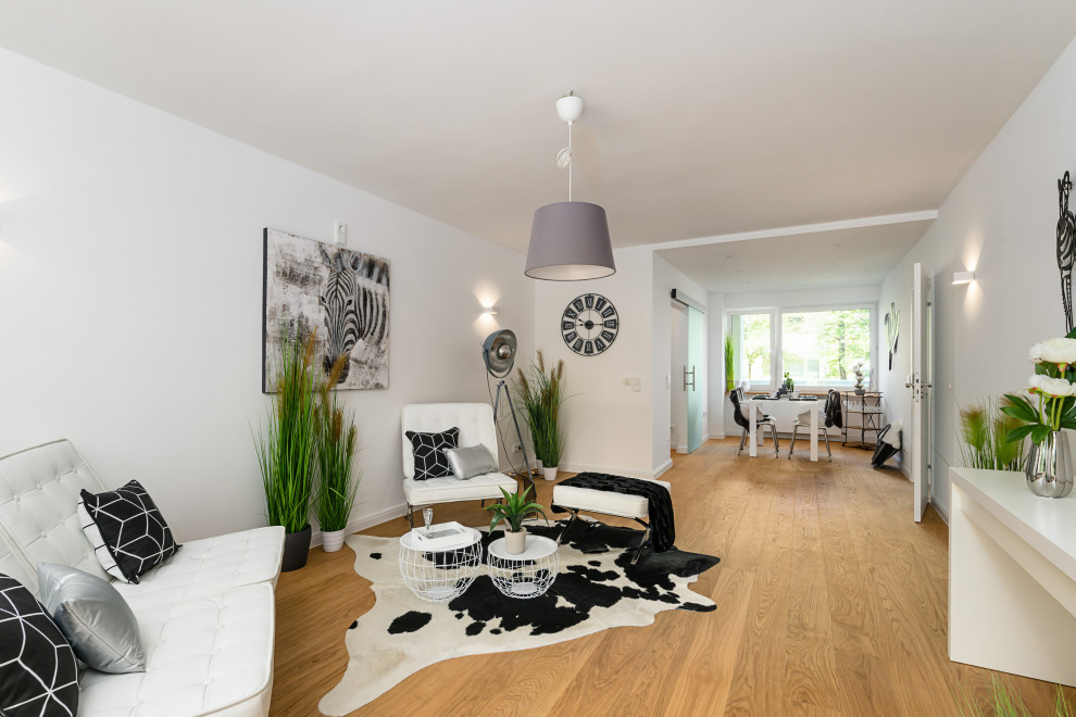Idée de décoration pour un salon tradition de taille moyenne et ouvert avec un mur blanc, un sol en bois brun et un sol marron.