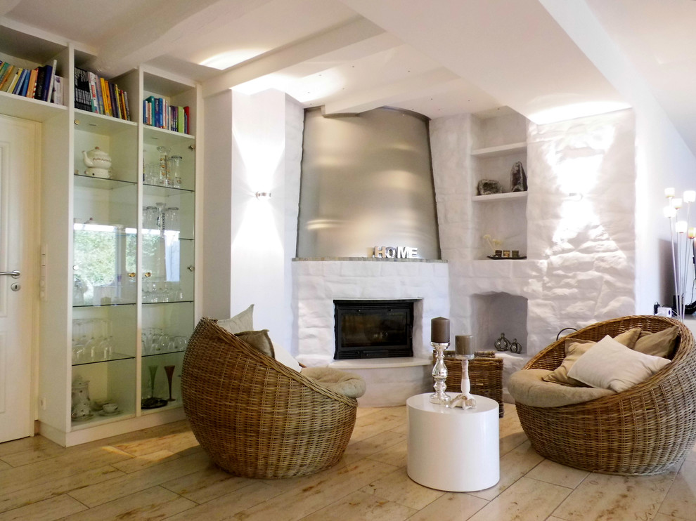 Immagine di un soggiorno minimal aperto con pareti bianche, pavimento in pietra calcarea, camino ad angolo, cornice del camino in mattoni e nessuna TV