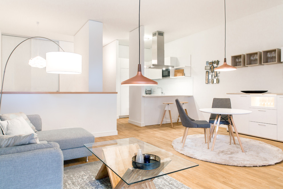 Living room - small scandinavian medium tone wood floor and brown floor living room idea in Hamburg with white walls