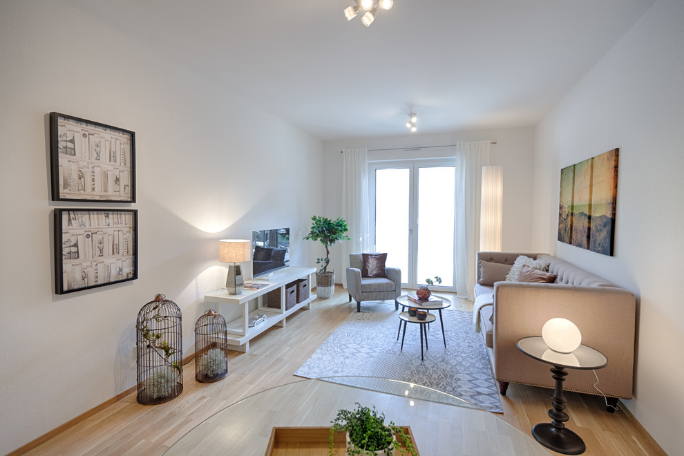 Mittelgroßes, Abgetrenntes Modernes Wohnzimmer ohne Kamin mit weißer Wandfarbe, Laminat, freistehendem TV und beigem Boden in Hannover