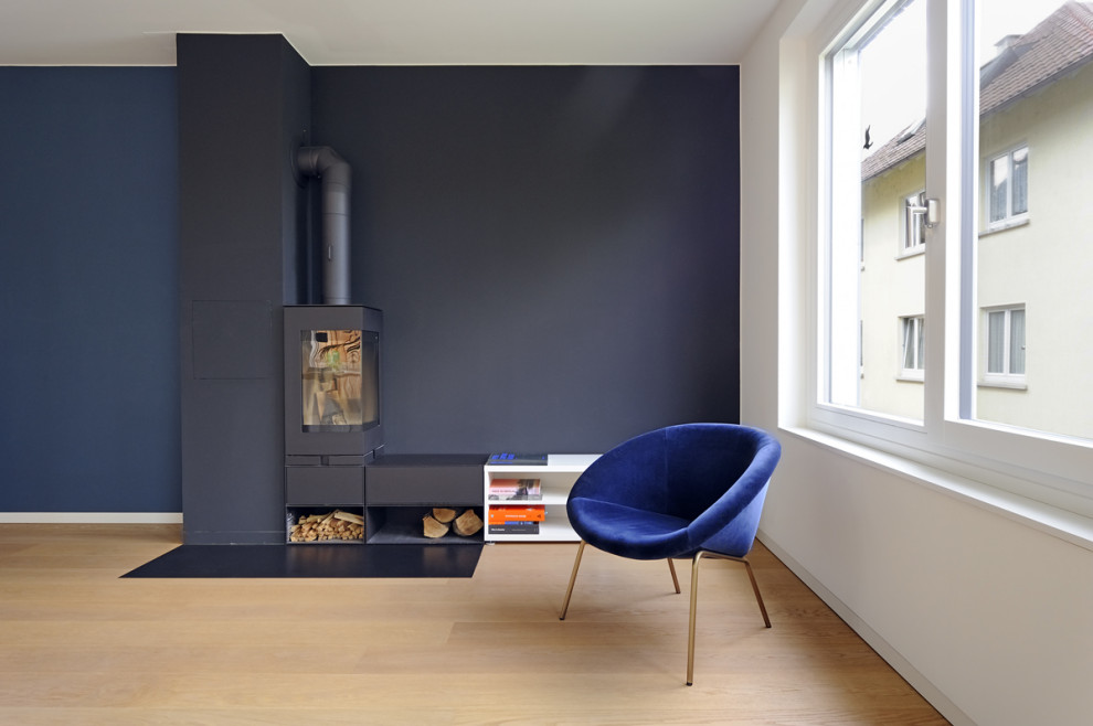 Geräumiges Skandinavisches Wohnzimmer mit schwarzer Wandfarbe, hellem Holzboden und Eckkamin in Stuttgart