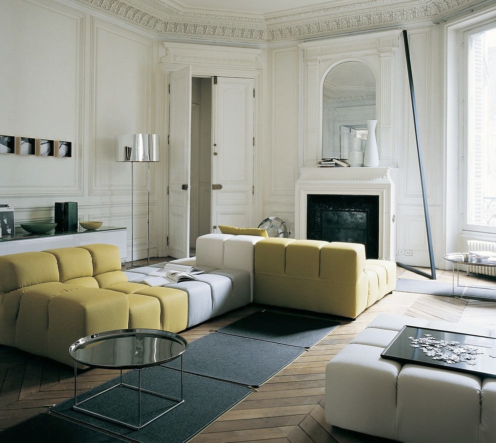 Mittelgroßes, Fernseherloses, Abgetrenntes Modernes Wohnzimmer mit weißer Wandfarbe, braunem Holzboden, Kamin, Kaminumrandung aus Stein und braunem Boden in Nürnberg