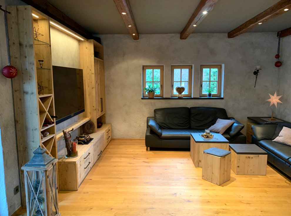 Inredning av ett rustikt mellanstort allrum med öppen planlösning, med ett finrum, grå väggar, ljust trägolv, en öppen vedspis och en väggmonterad TV