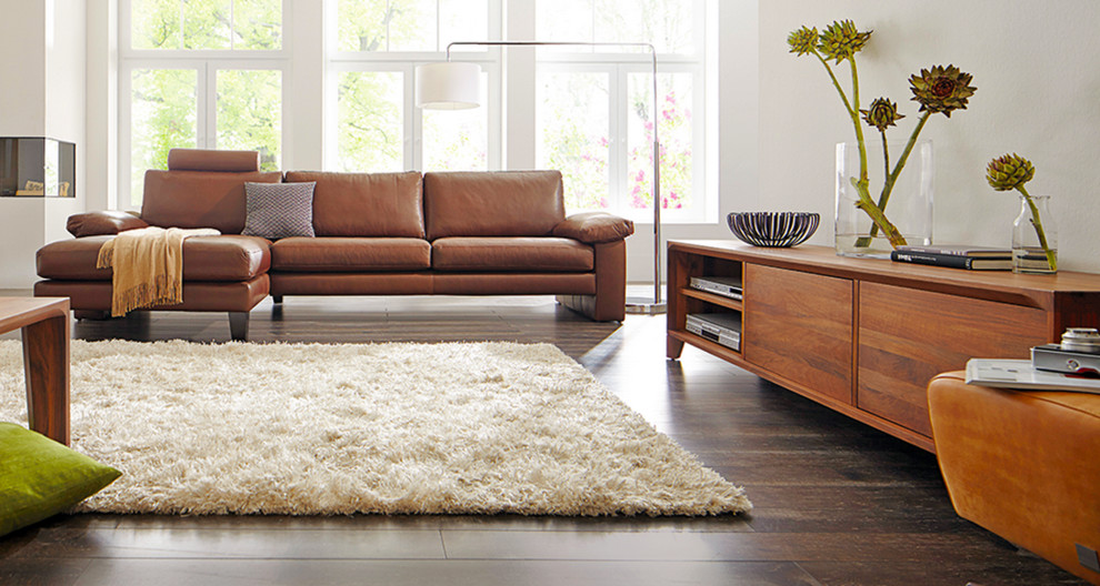 Foto de sala de estar contemporánea con paredes blancas, suelo de madera en tonos medios y chimenea de esquina