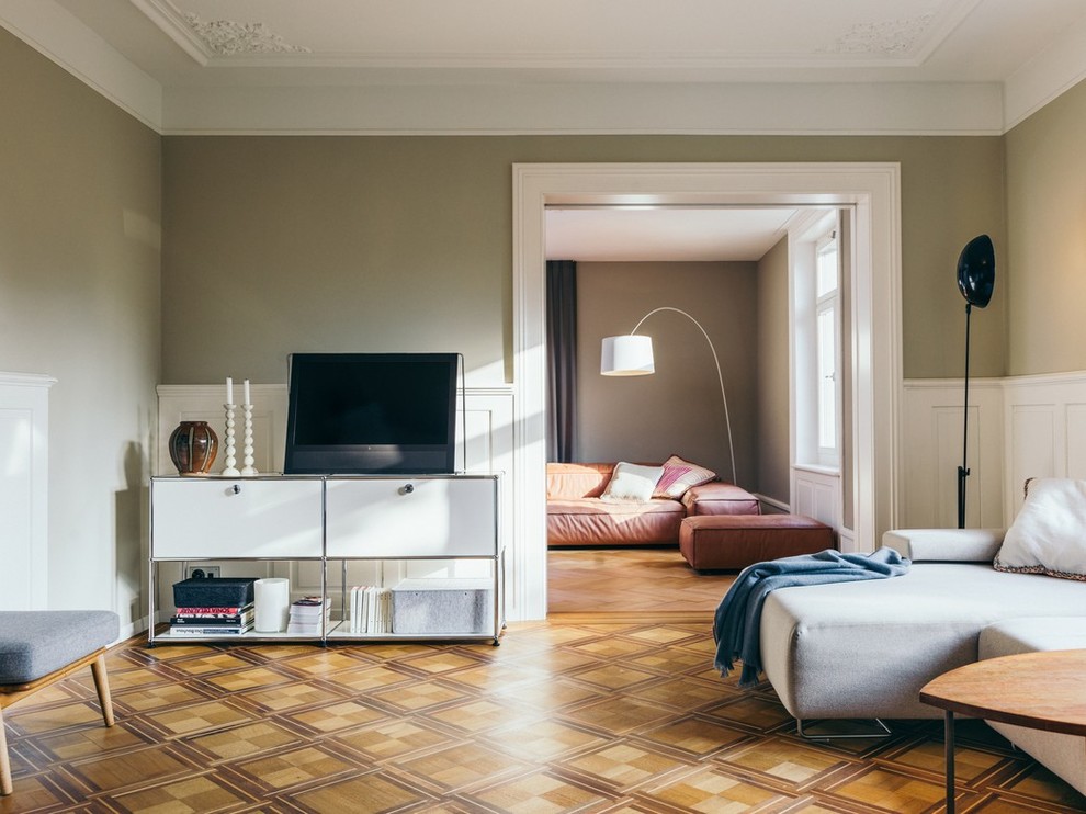 Mittelgroßes Klassisches Wohnzimmer mit grüner Wandfarbe, braunem Holzboden und buntem Boden in Sonstige