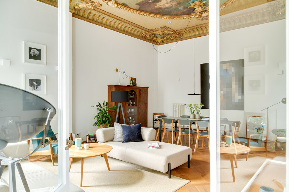 Geräumiges, Repräsentatives, Offenes Modernes Wohnzimmer mit weißer Wandfarbe, braunem Holzboden, verstecktem TV und braunem Boden in Düsseldorf