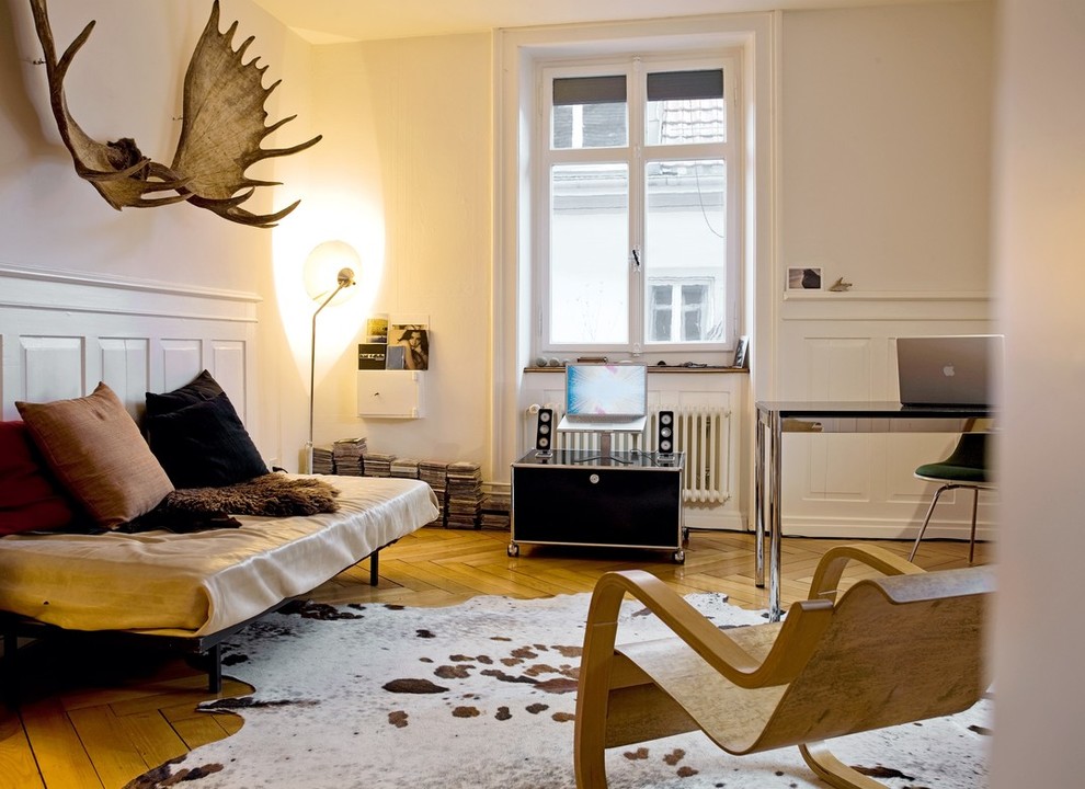 Inspiration for a mid-sized industrial enclosed medium tone wood floor living room remodel in Berlin with white walls