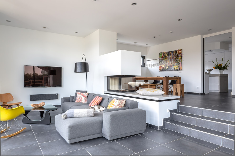 Medium sized contemporary open plan games room in Other with white walls, a two-sided fireplace, a plastered fireplace surround and a wall mounted tv.