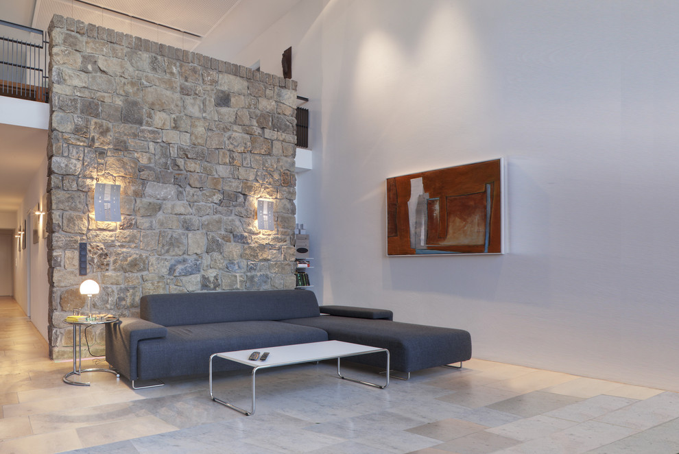 Idées déco pour un salon moderne ouvert avec un mur blanc et un mur en pierre.