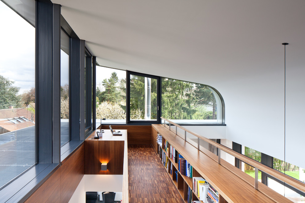 Diseño de biblioteca en casa tipo loft contemporánea de tamaño medio sin chimenea y televisor con paredes blancas y suelo de madera en tonos medios