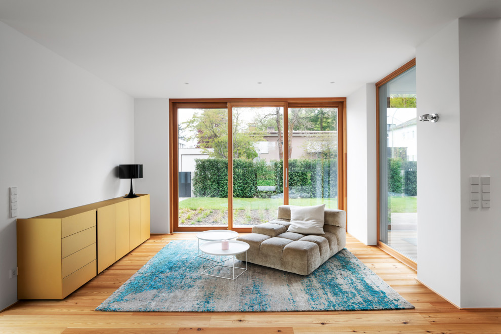 Cette image montre un grand salon minimaliste ouvert avec une salle de réception, un mur blanc, parquet clair, une cheminée d'angle, un manteau de cheminée en pierre, un téléviseur encastré et un sol marron.