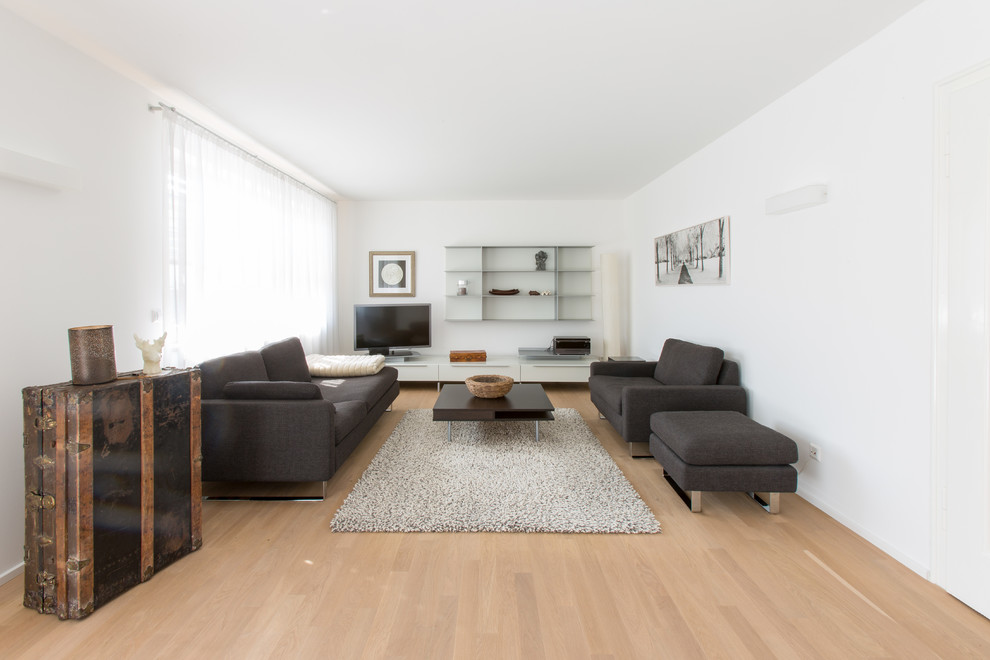 Großes, Abgetrenntes Modernes Wohnzimmer ohne Kamin mit weißer Wandfarbe, hellem Holzboden und freistehendem TV in Stuttgart
