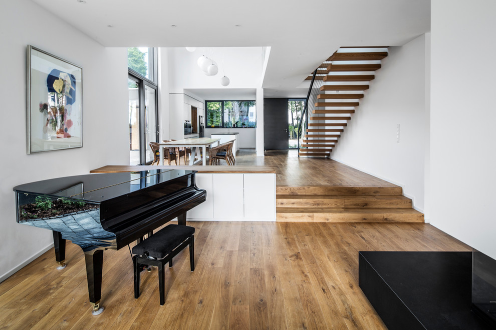 Inspiration for an expansive contemporary open plan living room in Cologne with white walls, medium hardwood flooring, no fireplace, no tv and a music area.