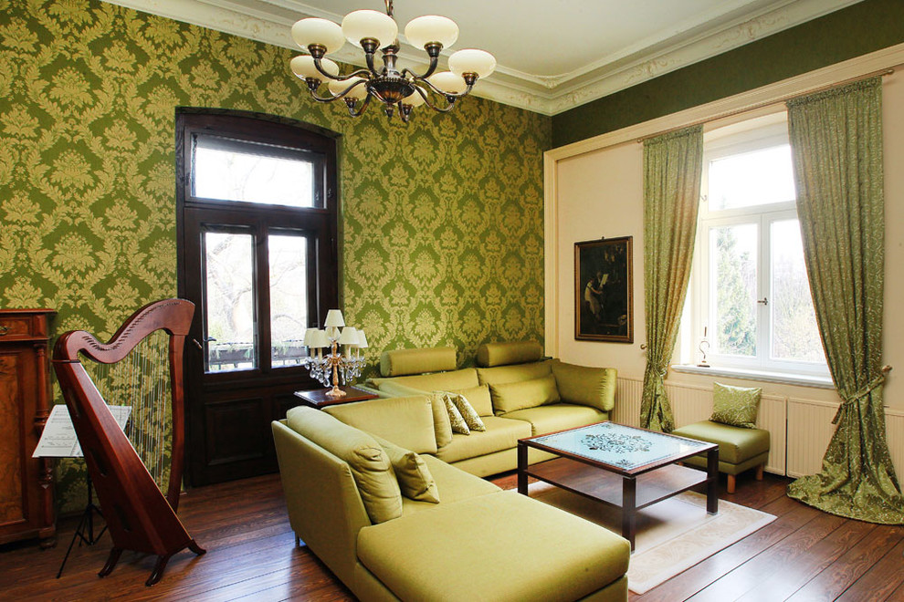 Diseño de sala de estar con rincón musical cerrada clásica grande sin chimenea y televisor con paredes verdes y suelo de madera oscura