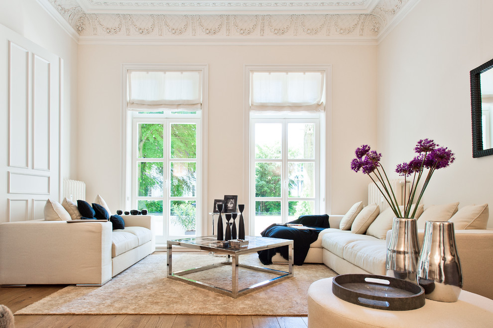 Imagen de salón para visitas cerrado contemporáneo grande con paredes blancas y suelo de madera en tonos medios