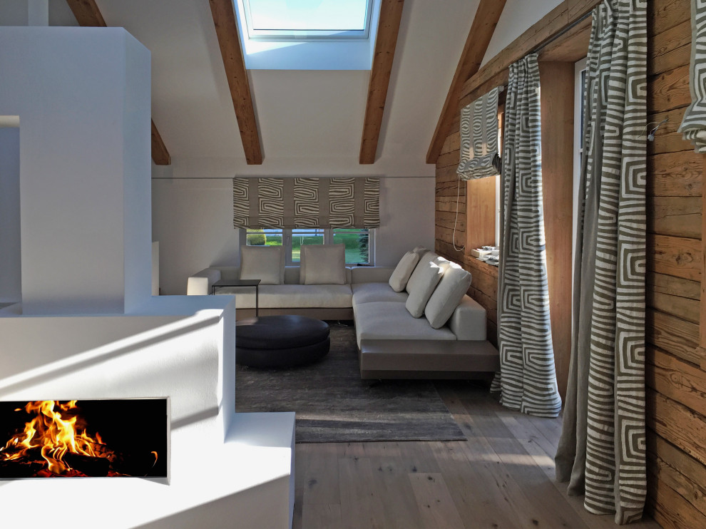 Mittelgroßes Modernes Wohnzimmer im Loft-Stil mit weißer Wandfarbe, gebeiztem Holzboden, Gaskamin, verputzter Kaminumrandung und beigem Boden in München