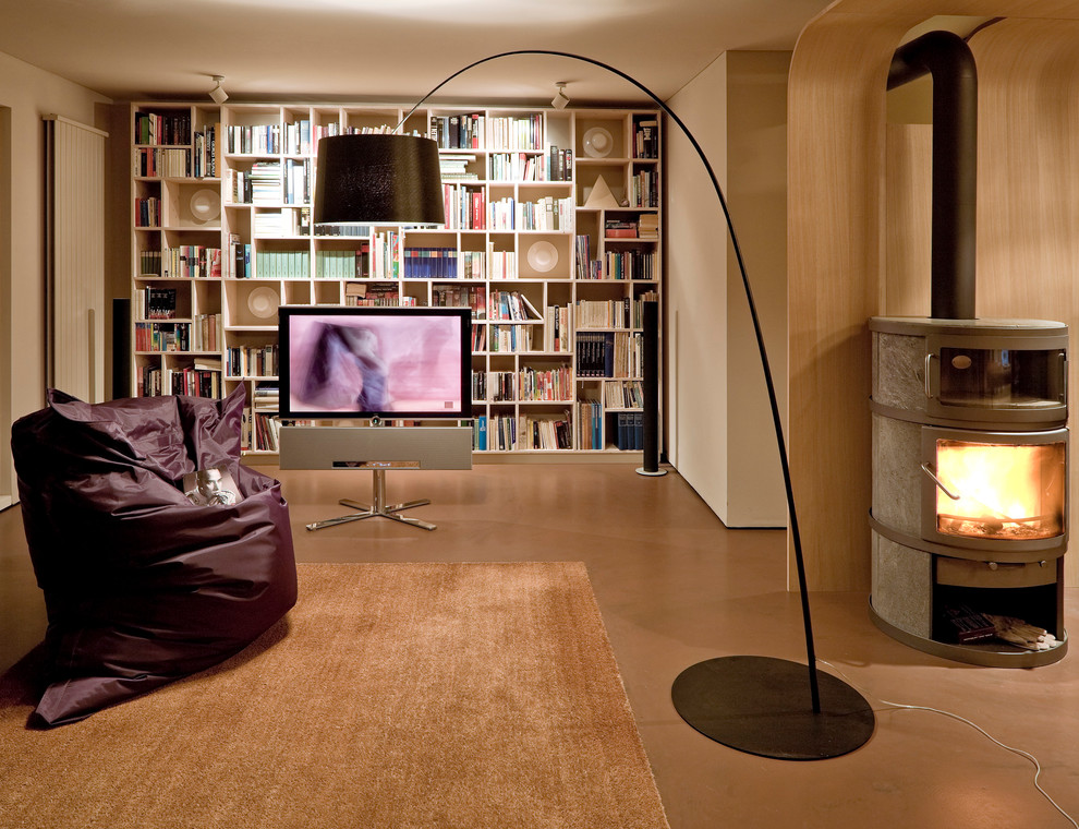 Exemple d'un grand salon tendance ouvert avec une bibliothèque ou un coin lecture, un mur gris, un poêle à bois, un manteau de cheminée en métal et un téléviseur indépendant.
