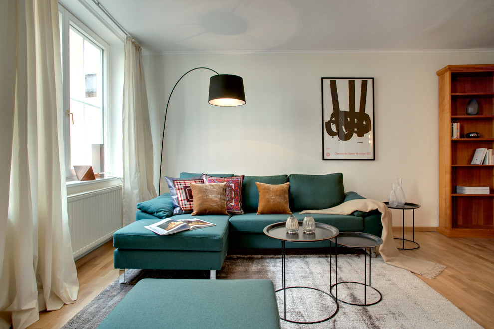 Diseño de sala de estar cerrada actual de tamaño medio sin chimenea y televisor con paredes blancas y suelo de madera clara