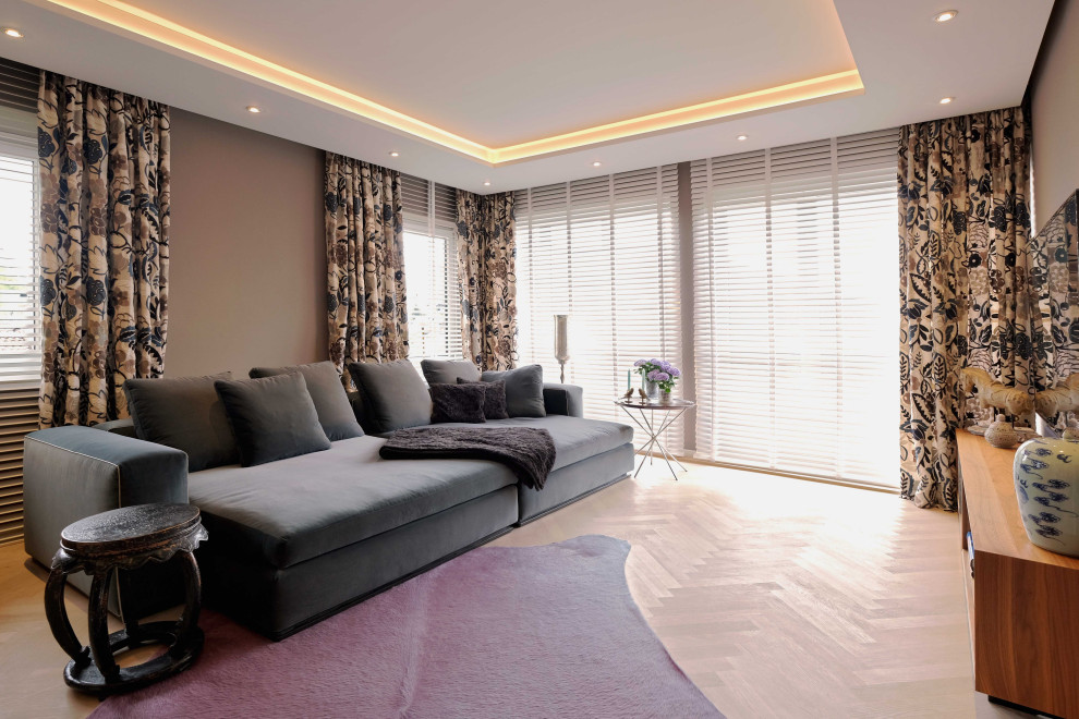 Esempio di un grande soggiorno design chiuso con pareti beige, parquet chiaro, stufa a legna, cornice del camino in intonaco e pavimento bianco