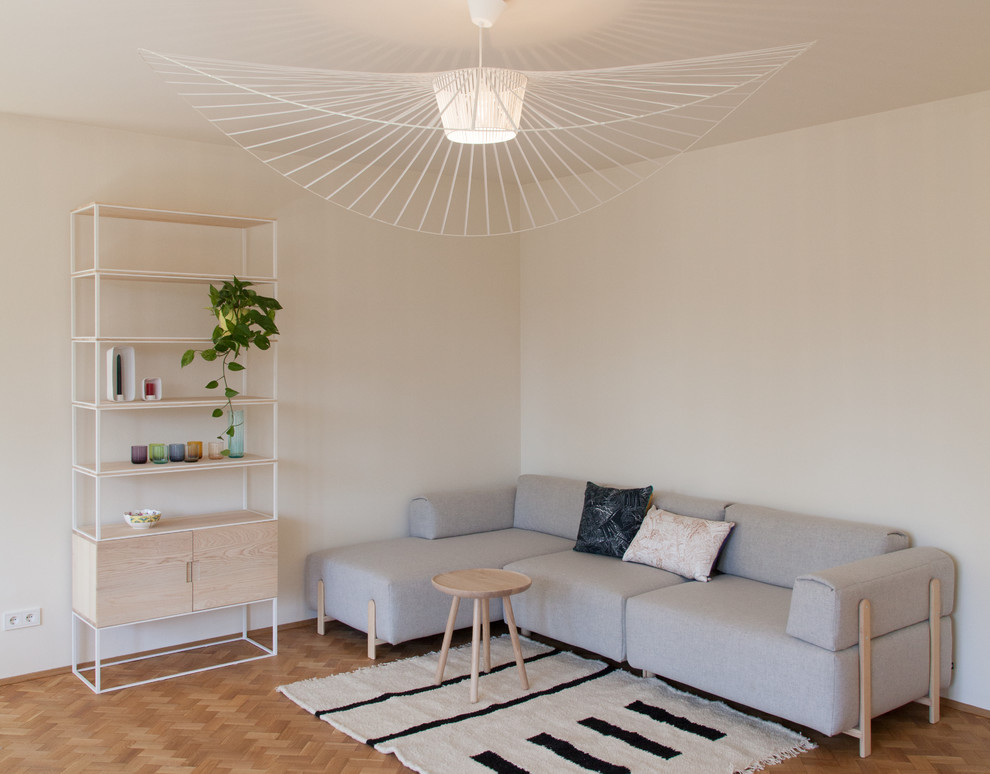 Kleines, Fernseherloses, Abgetrenntes Nordisches Wohnzimmer ohne Kamin mit weißer Wandfarbe, braunem Holzboden und braunem Boden in Berlin