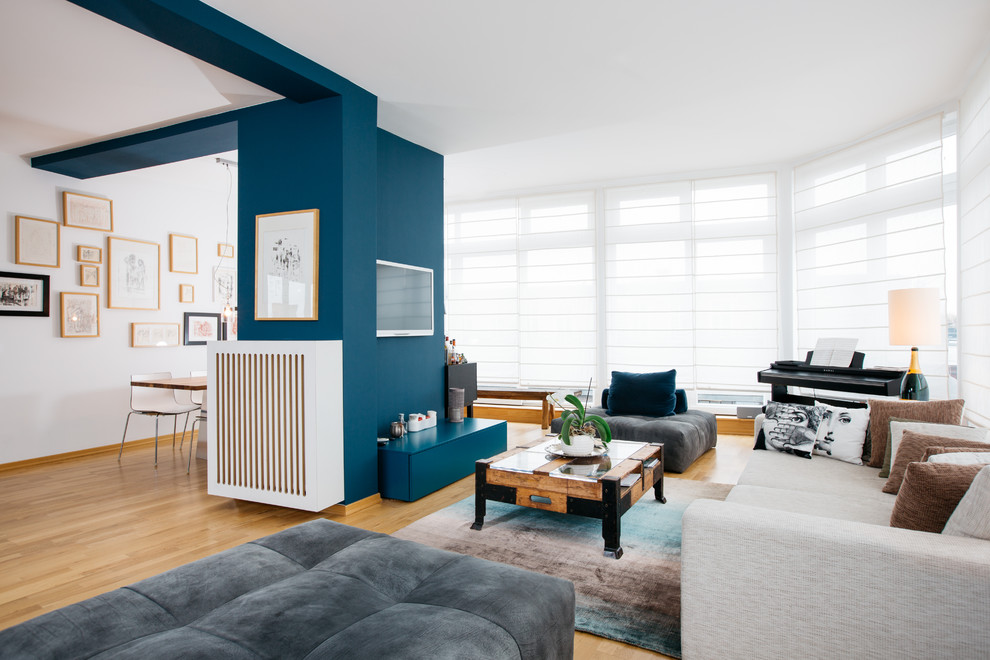 Esempio di un grande soggiorno contemporaneo aperto con pareti blu, parquet chiaro, nessun camino, TV a parete, pavimento beige e sala formale