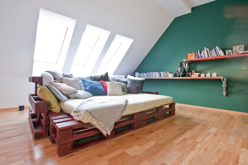 Пример оригинального дизайна: большая открытая гостиная комната в современном стиле с с книжными шкафами и полками, зелеными стенами, паркетным полом среднего тона, отдельно стоящим телевизором и коричневым полом