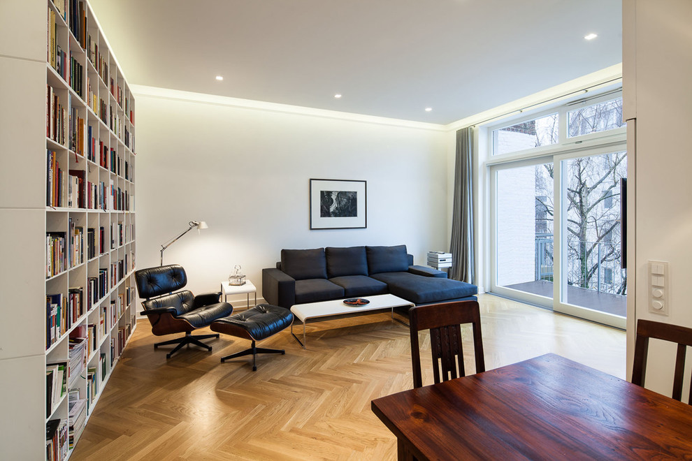 Inspiration for a medium sized contemporary open plan games room in Dusseldorf with a reading nook, white walls, medium hardwood flooring, no fireplace and brown floors.