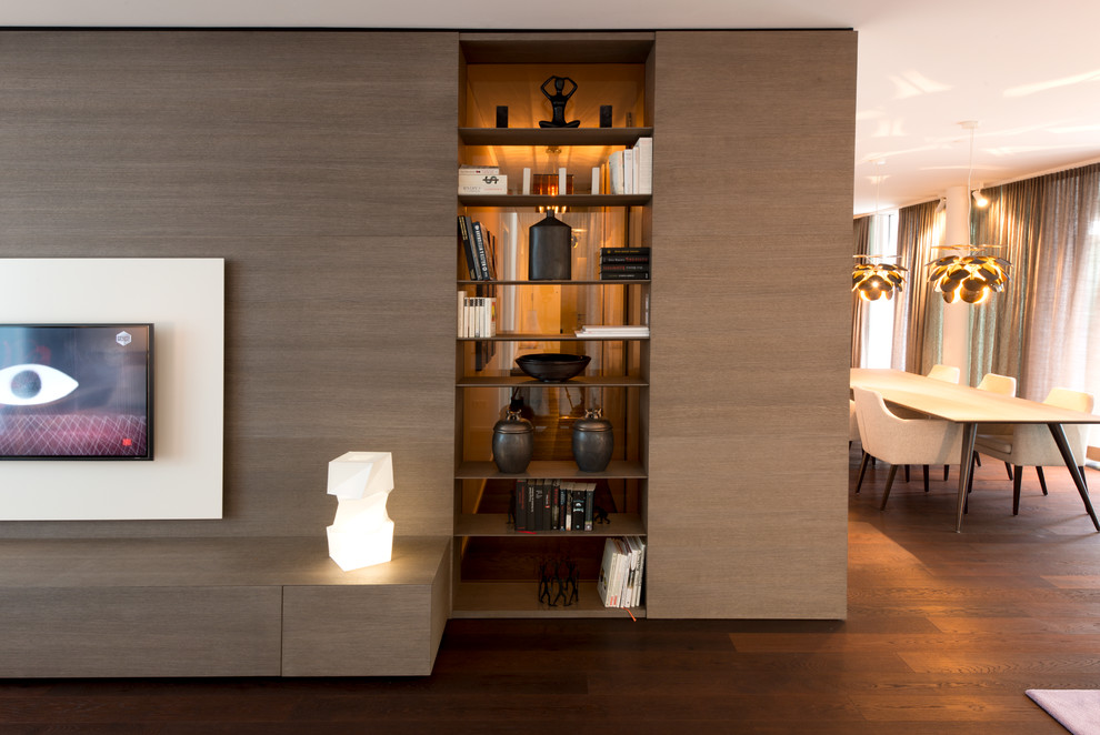 Immagine di un soggiorno contemporaneo aperto con pareti marroni, parquet scuro e TV a parete