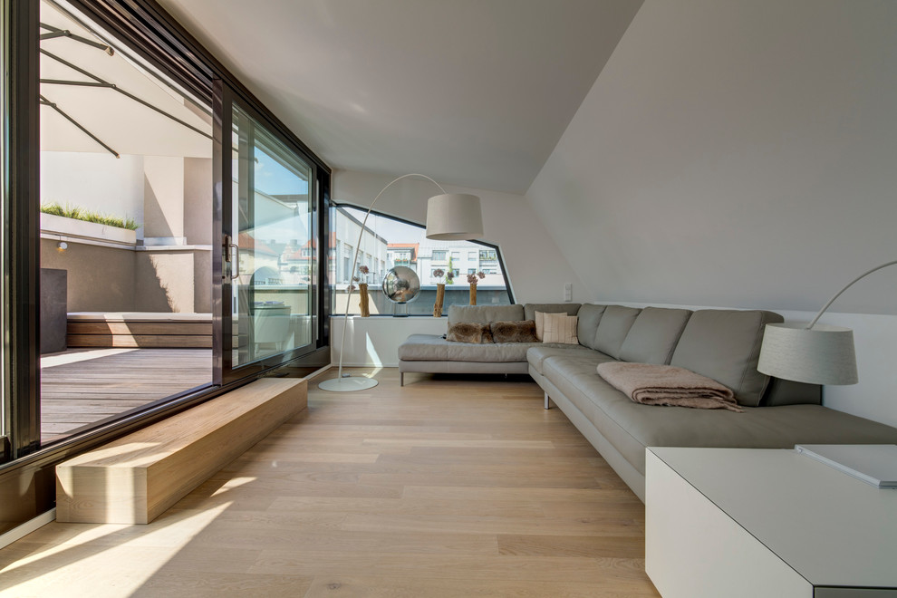 Mittelgroßes, Repräsentatives, Fernseherloses, Abgetrenntes Modernes Wohnzimmer ohne Kamin mit hellem Holzboden und grauer Wandfarbe in München