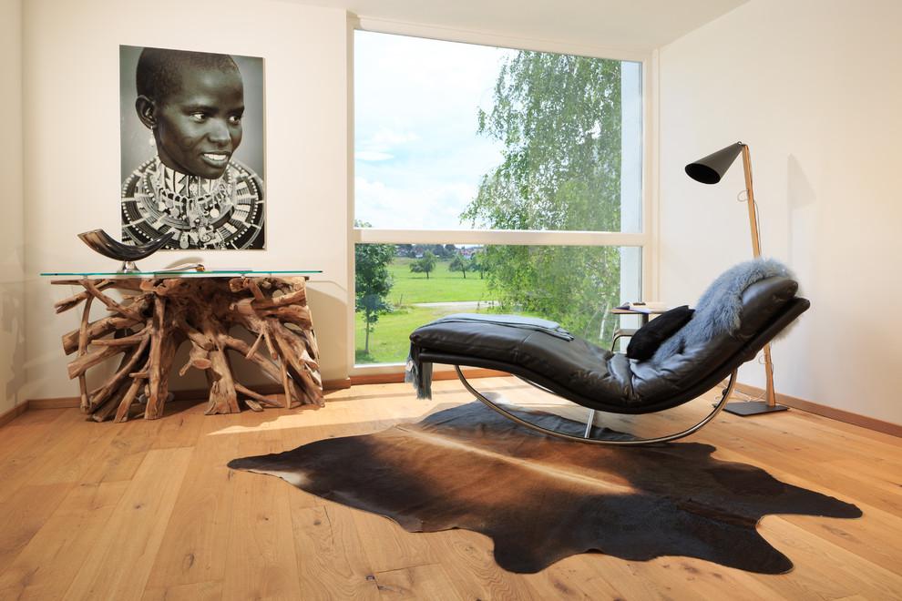 Immagine di un piccolo soggiorno contemporaneo con pareti bianche, pavimento in legno massello medio e pavimento marrone