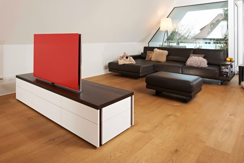 Mittelgroßes Modernes Wohnzimmer ohne Kamin mit weißer Wandfarbe, braunem Holzboden, freistehendem TV und braunem Boden in Stuttgart