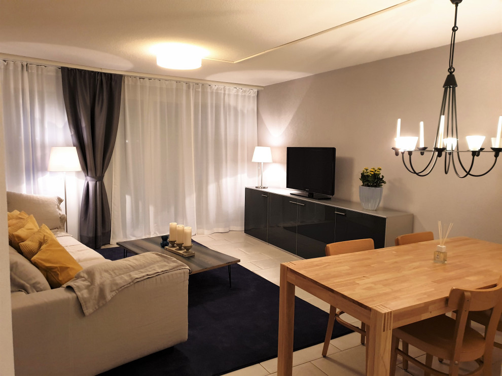 Идея дизайна: маленькая открытая гостиная комната в стиле модернизм с серыми стенами, полом из известняка, отдельно стоящим телевизором и белым полом без камина для на участке и в саду