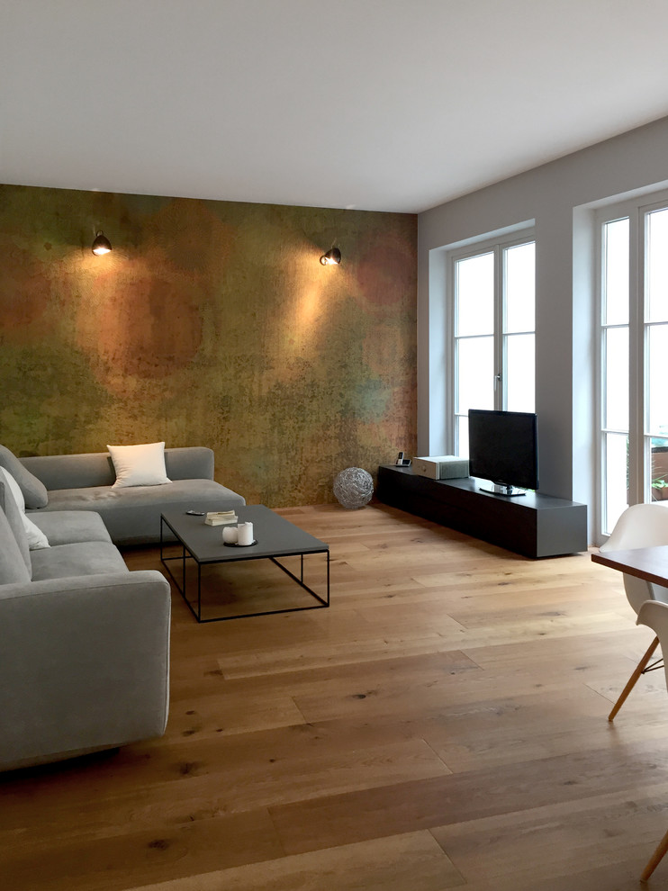 Mittelgroßes, Offenes Modernes Wohnzimmer ohne Kamin mit weißer Wandfarbe, hellem Holzboden, freistehendem TV und beigem Boden in Köln
