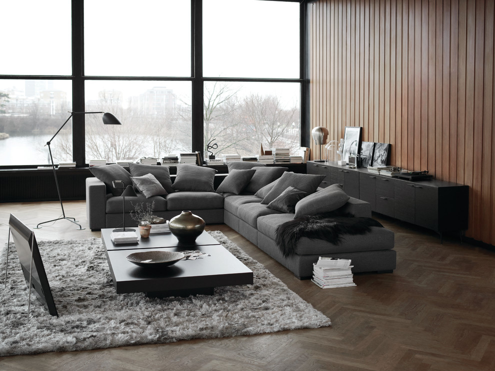 Großes, Offenes Modernes Wohnzimmer mit brauner Wandfarbe, braunem Holzboden und freistehendem TV in Düsseldorf