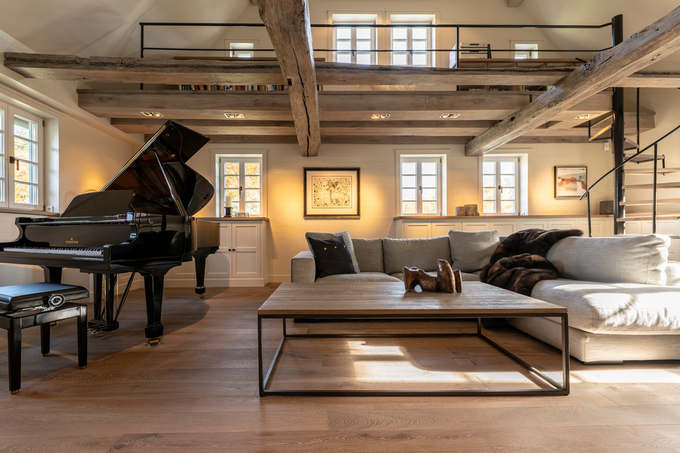 Inspiration for an expansive farmhouse open plan games room in Frankfurt with a reading nook, white walls, a ribbon fireplace, a plastered fireplace surround, a concealed tv, grey floors and painted wood flooring.