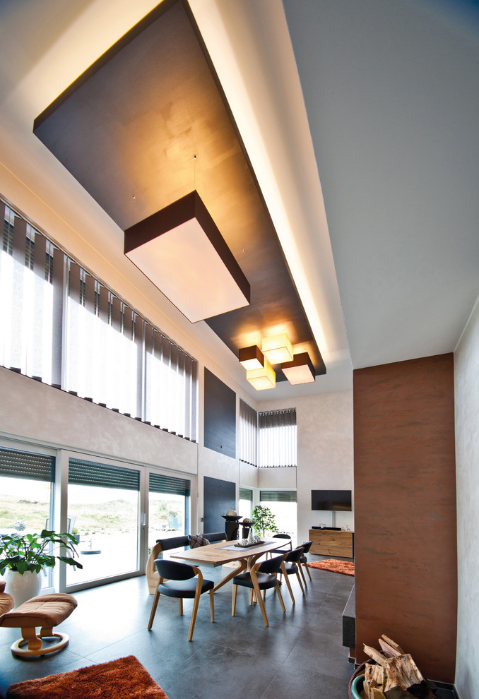 Esempio di un ampio soggiorno minimal stile loft con sala formale, pareti grigie, TV a parete e pavimento grigio