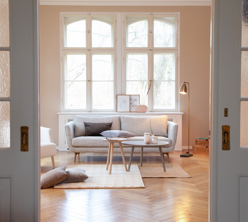 Esempio di un grande soggiorno scandinavo chiuso con pareti rosa, pavimento in legno massello medio, nessun camino, nessuna TV, pavimento marrone e carta da parati
