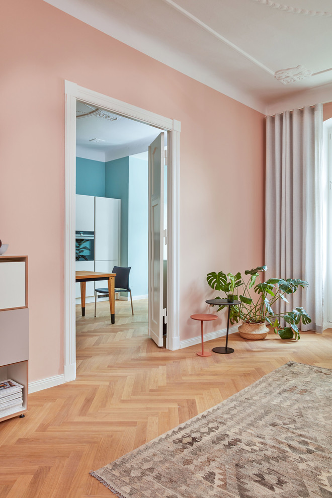 Idée de décoration pour une salle de séjour design fermée avec un mur rose, un sol en bois brun et un sol marron.